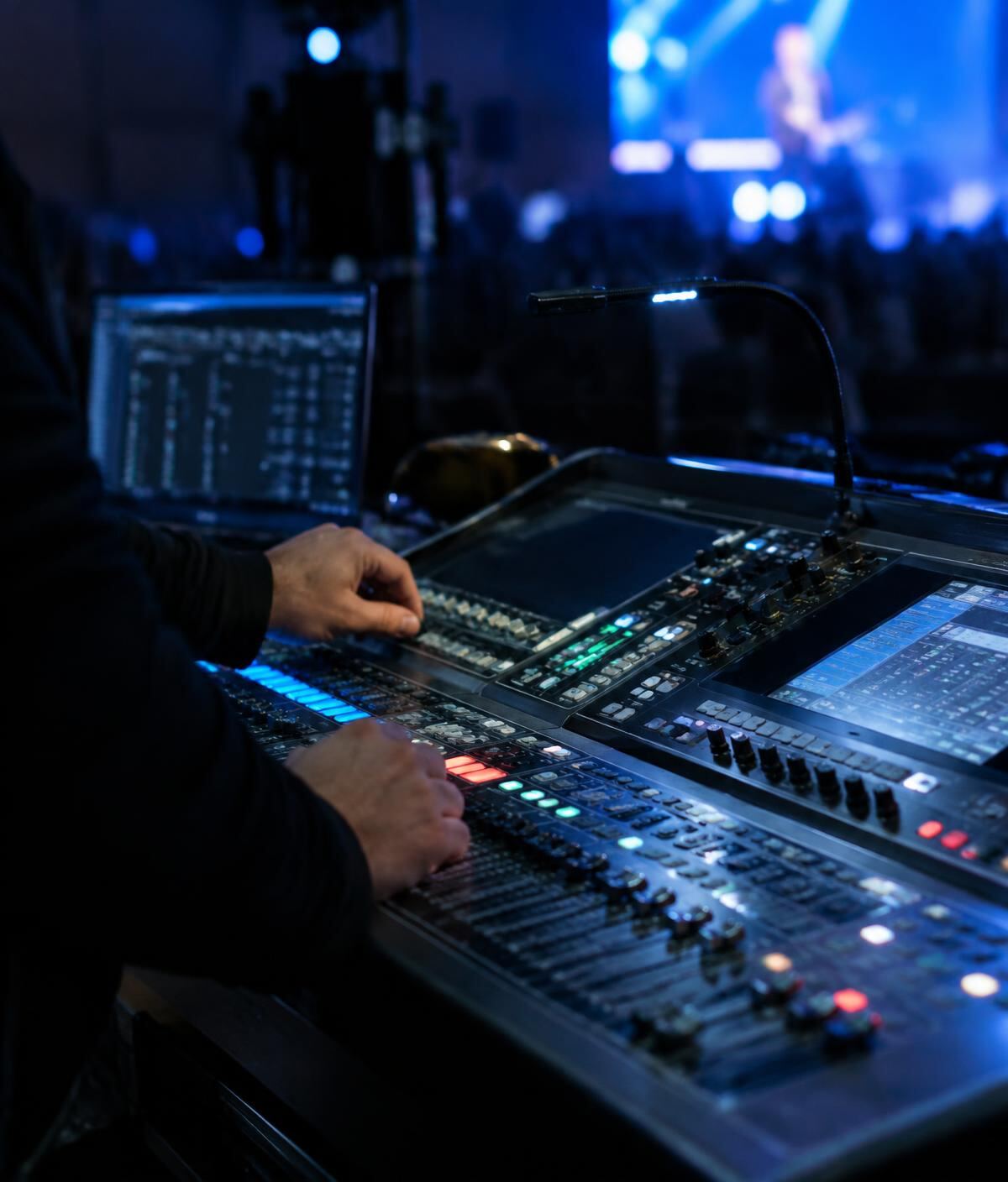 AV technician operating a digital mixing console at an event